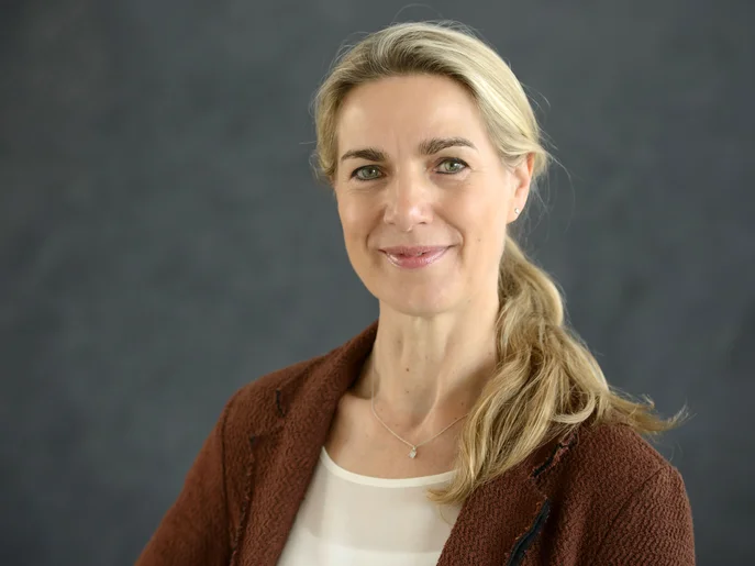 freundlich blickende blonde Frau mit einen Zopf